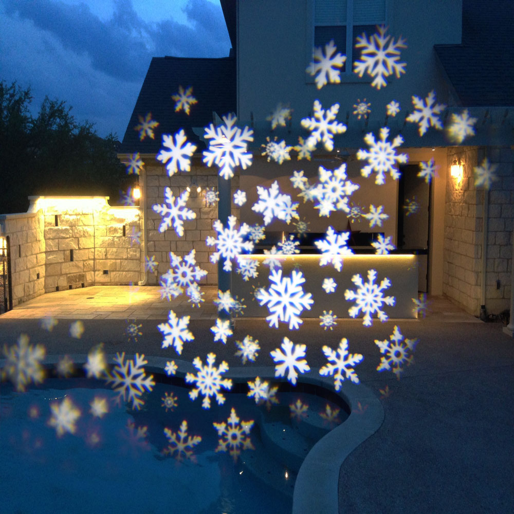 Proyección de copos de nieve en la pared de la casa